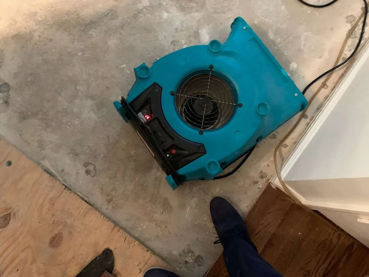 Air mover drying subfloor during Commercial Water Damage Restoration in Conway